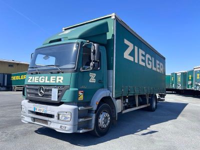 un camion vert garé sur un parking