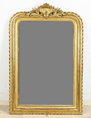 a gold framed mirror sitting on top of a wooden floor