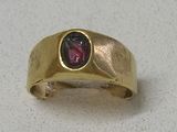an image of a gold ring with a garnett stone