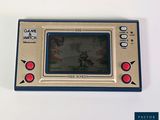 a game and watch sitting on a white table