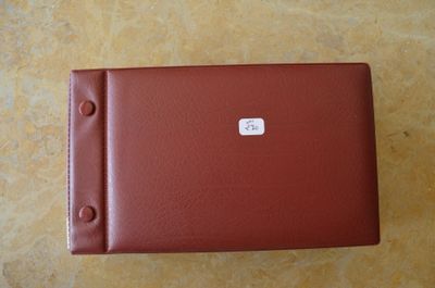 un étui rouge muni d'un bouton, posé sur une table