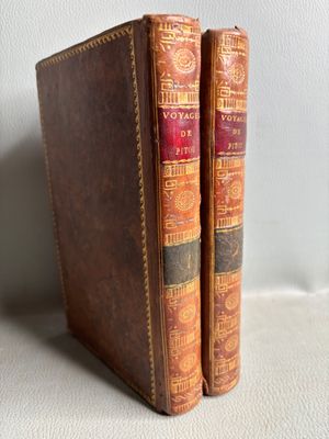 deux vieux livres posés l'un à côté de l'autre sur une table blanche