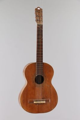 a close up of a guitar hanging on a wall