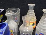 many different types of bottles and glasses sitting on a table