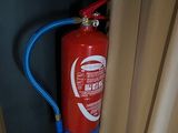 a fire extinguisor attached to a wall next to a window