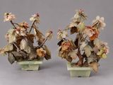 deux vases ornés de fleurs et de feuilles, posés sur un fond gris