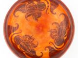 a brown bowl with designs on it on a white surface