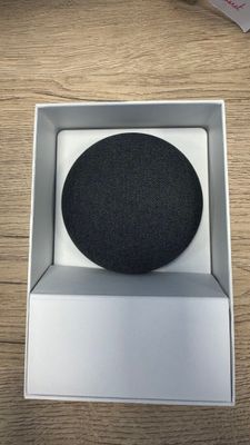 an image of a black speaker in a white box on a wooden table