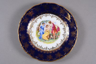 a blue and gold plate with a painting on it