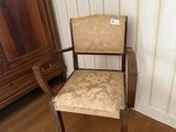 une chaise dans un coin de la pièce, à côté d'une armoire