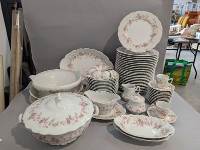 une table sur laquelle se trouvent beaucoup d'assiettes et de bols