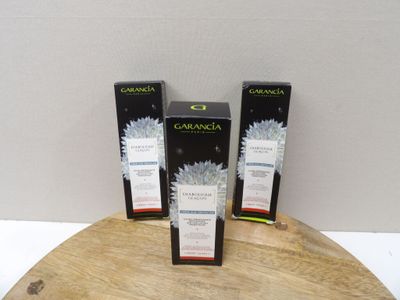trois boîtes de Garnier posées sur une table en bois