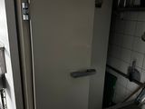 a white refrigerator in a small kitchen with a window