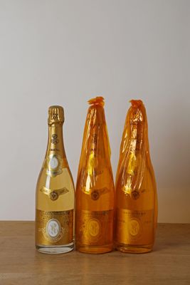 trois bouteilles de champagne posées côte à côte sur une table