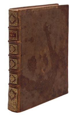 un vieux livre à la couverture brune posé sur une surface blanche