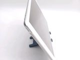 a tablet computer sitting on a stand on a white surface