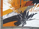 an image of a square scarf with orange, black, and white flowers