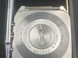 a watch and a pen in a box with a pen in it