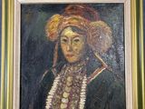 tableau représentant une femme coiffée d'un chapeau à plumes, dans un cadre doré sur fond bleu