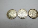 three different coins are shown on a white surface