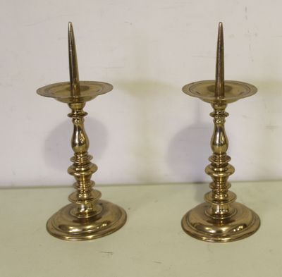 une paire de bougeoirs en laiton posés sur une table verte