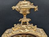 a gold clock with a clock face on top of it