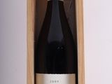 la bouteille de vin se trouve dans un coffret en bois posé sur une surface blanche