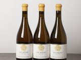 three bottles of wine sitting on top of a wooden table