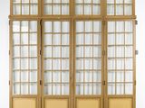 une grande armoire en bois avec des portes vitrées et un tapis au sol