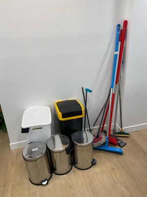 a lot of trash cans and brooms in the corner of the room