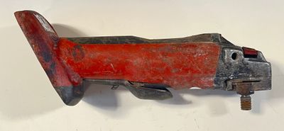 un coupe-tube rouge et noir posé sur une surface blanche
