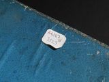 a small piece of paper that is on top of a blue suitcase
