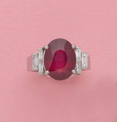 gros plan d'une bague avec une pierre rouge entourée de diamants blancs