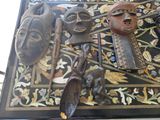 une table sur laquelle sont disposés de nombreux objets africains