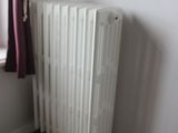 a radiator in the corner of a room next to a window