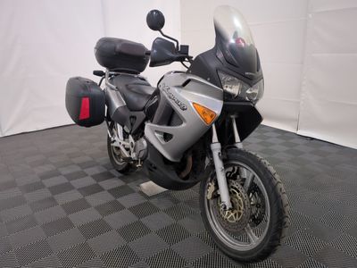 une moto qui est garée dans une pièce dont le sol est en damier