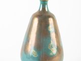 a blue and gold vase sitting on a white surface