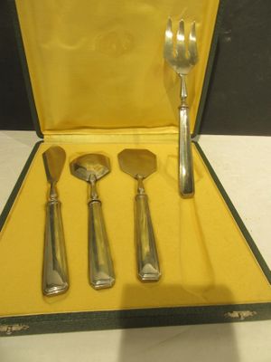 quatre fourchettes et cuillères dans un étui posé sur une table