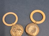 pair of gold earrings with a lion head on the front and a gold coin on the back
