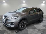 une Nissan QX-V grise garée sur un sol à damier
