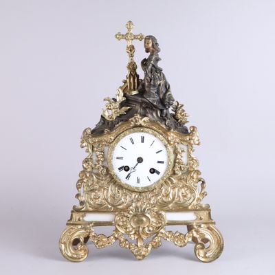a gold clock with a statue on top of it