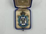 une petite boîte bleue contenant une médaille argentée et bleue