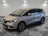 une voiture argentée est garée dans une pièce au sol en damier
