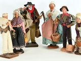 five figurines of people dressed in historical clothing