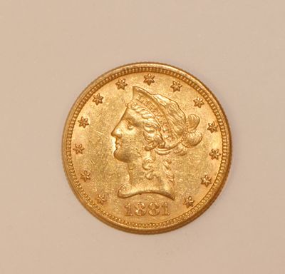 a close up of a gold coin with a woman ' s head on it