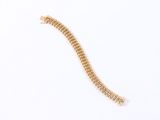 a close up of a gold bracelet on a white surface