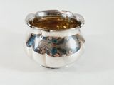 a silver vase with a picture on it on a white surface