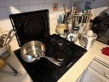 a stove top with pots and pans on it in a kitchen