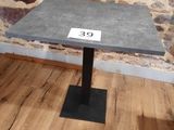 une petite table sur laquelle est inscrit un chiffre, devant un mur de pierre