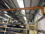 a picture of a crane in a warehouse with lots of shelves